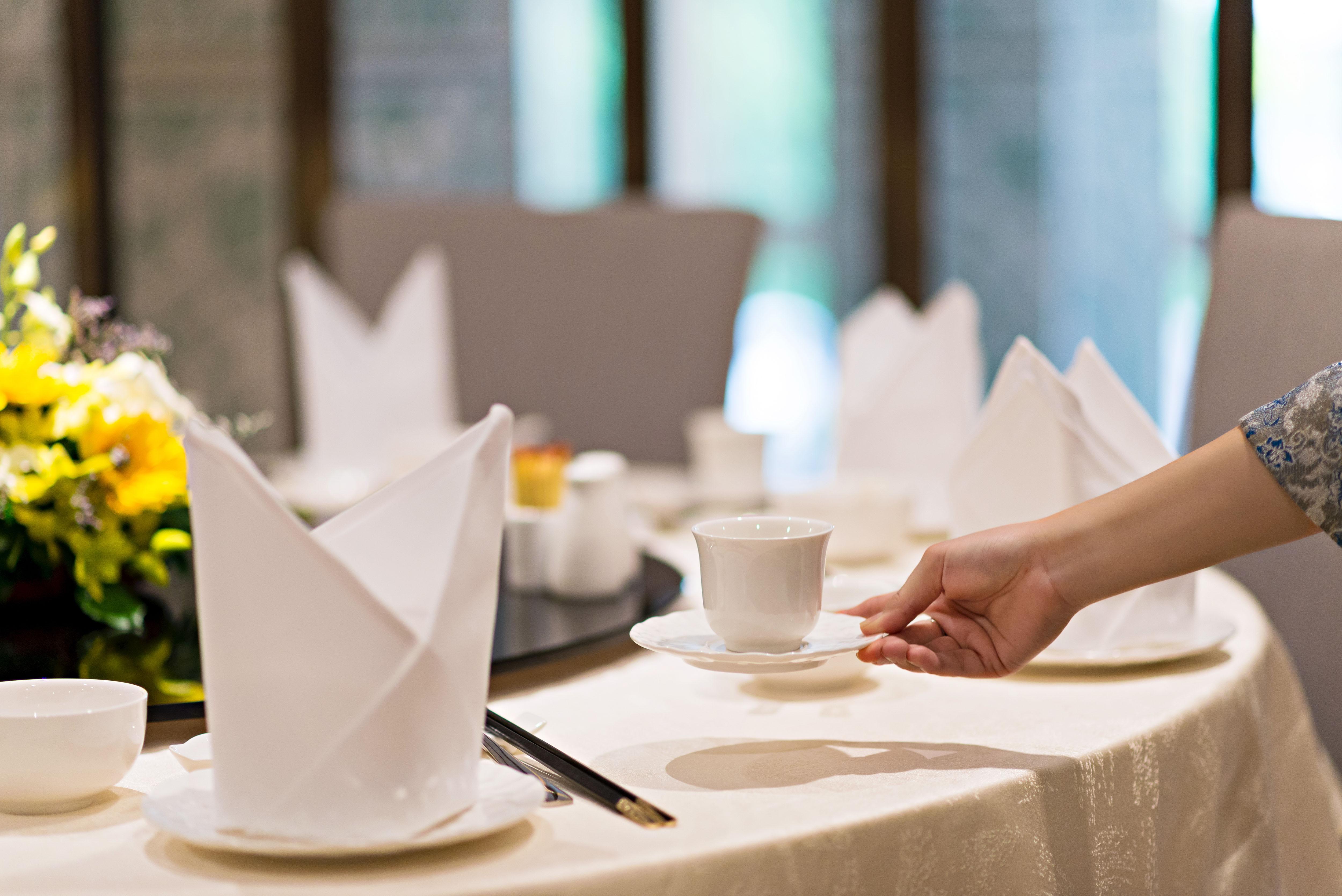 Eastin Grand Hotel Saigon Ho Chi Minh City Exterior photo A server sets a table at a restaurant.